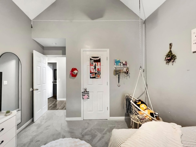 bedroom with high vaulted ceiling, baseboards, and carpet