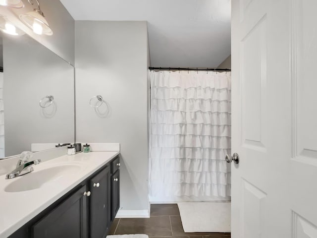bathroom featuring baseboards, tile patterned flooring, and vanity