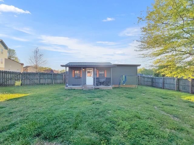 back of property with a fenced backyard and a yard