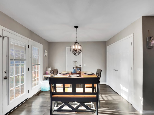 dining area featuring a notable chandelier, baseboards, and dark wood-style flooring