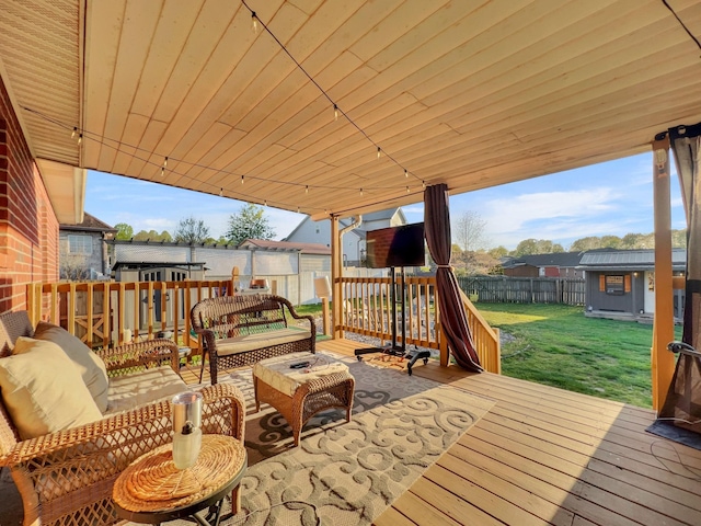 wooden terrace featuring outdoor lounge area, a fenced backyard, a storage shed, an outdoor structure, and a lawn