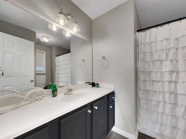 full bath with baseboards, vanity, and curtained shower
