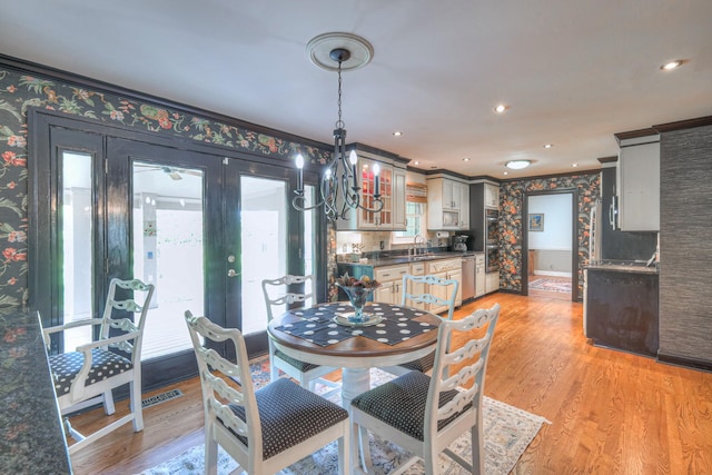 1143 Carnton Ln, Franklin, TN 37064 - dining space with ornamental molding, light wood finished floors, a notable chandelier, and wallpapered walls