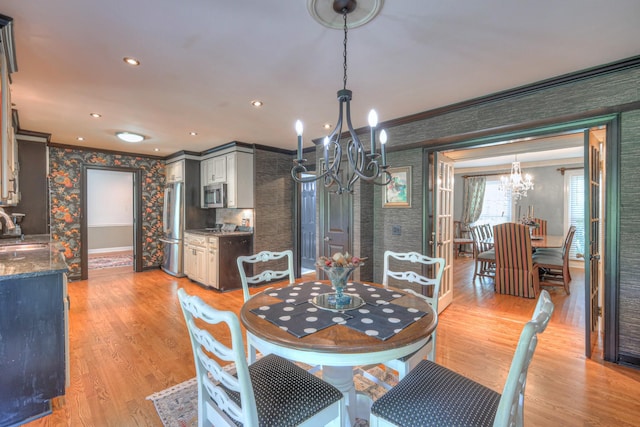 1143 Carnton Ln, Franklin, TN 37064 - dining area featuring baseboards, ornamental molding, wallpapered walls, a chandelier, and light wood finished floors