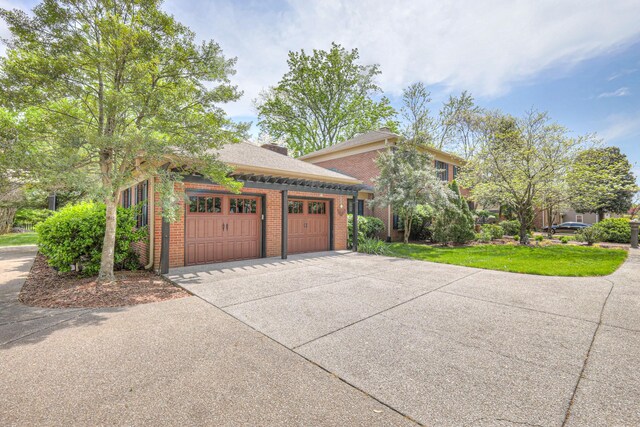 1143 Carnton Ln, Franklin, TN 37064 - view of side of property featuring an attached garage, a lawn, driveway, and brick siding