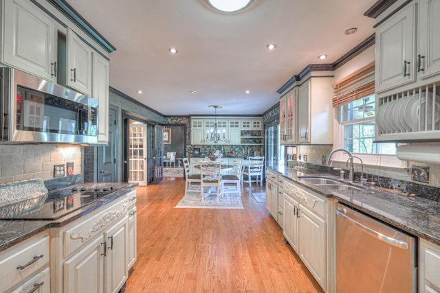 1143 Carnton Ln, Franklin, TN 37064 - kitchen featuring a sink, light wood-style flooring, crown molding, and stainless steel appliances