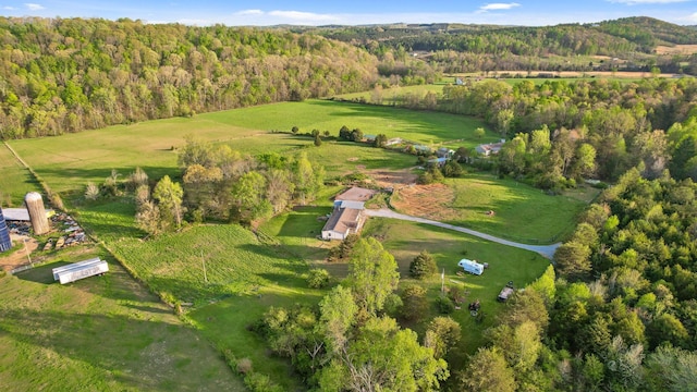 drone / aerial view featuring a view of trees and a rural view