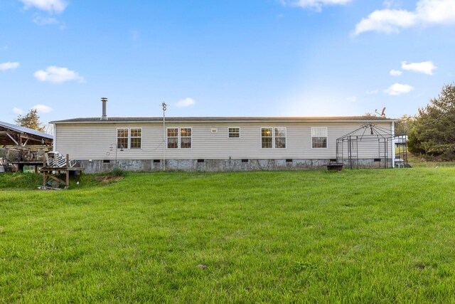 back of property with crawl space and a lawn