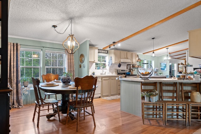 dining space featuring crown molding, light wood finished floors, a notable chandelier, and a textured ceiling