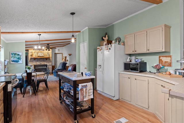 kitchen featuring light countertops, stainless steel microwave, white fridge with ice dispenser, and a textured ceiling