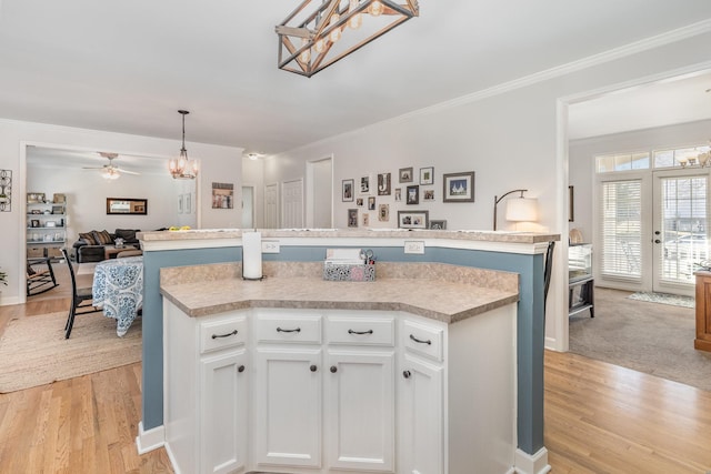 kitchen with open floor plan, light wood-style floors, a center island, and light countertops