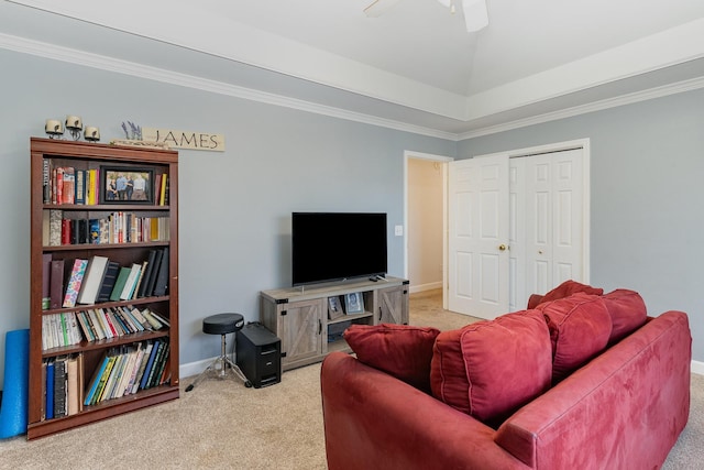 living area with a ceiling fan, baseboards, ornamental molding, and carpet