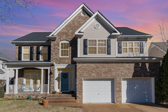 view of front of house featuring a porch, a garage, driveway, and brick siding