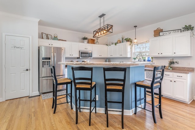 kitchen with stainless steel appliances, white cabinetry, and crown molding