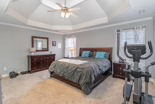 carpeted bedroom featuring visible vents, baseboards, ornamental molding, a ceiling fan, and a tray ceiling