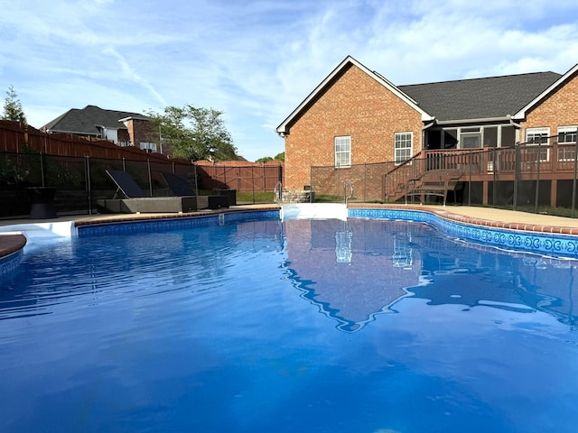 view of swimming pool with a wooden deck, fence, and a fenced in pool
