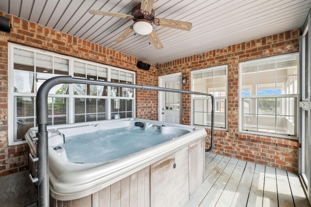 sunroom with a jacuzzi and a ceiling fan