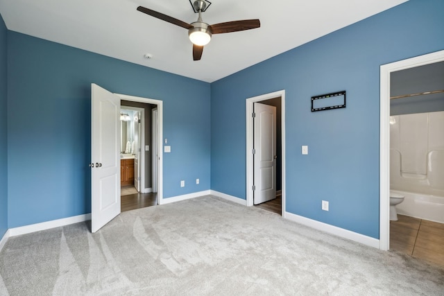 unfurnished bedroom featuring carpet floors, a ceiling fan, baseboards, and connected bathroom