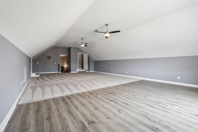 additional living space with vaulted ceiling, wood finished floors, and baseboards