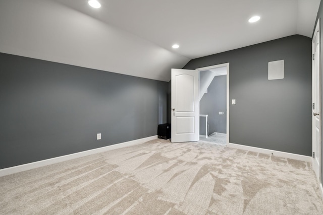 additional living space with baseboards, lofted ceiling, light carpet, and recessed lighting