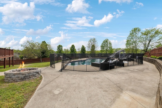 view of swimming pool with a fenced in pool, a fenced backyard, a yard, a patio area, and an outdoor fire pit