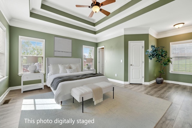 bedroom with baseboards, light wood-style flooring, visible vents, and crown molding