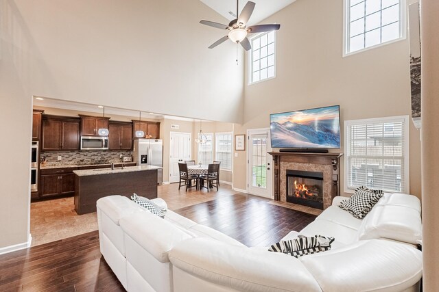 133 Kildeer Dr, Clarksville, TN 37040 - living area with baseboards, ceiling fan, dark wood-style floors, a fireplace with flush hearth, and a towering ceiling