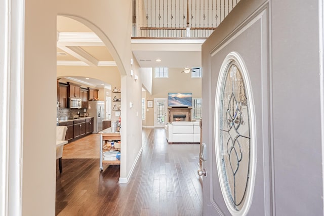 133 Kildeer Dr, Clarksville, TN 37040 - foyer entrance featuring hardwood / wood-style floors, a high ceiling, a warm lit fireplace, and arched walkways