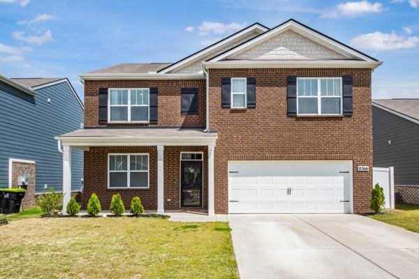 view of front of home featuring brick siding, an attached garage, a front yard, and concrete driveway