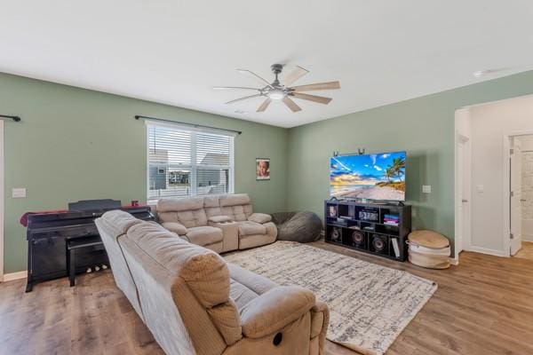 living room with baseboards, a ceiling fan, and wood finished floors