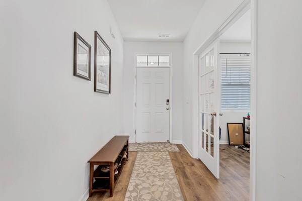 foyer entrance featuring light wood-type flooring and baseboards