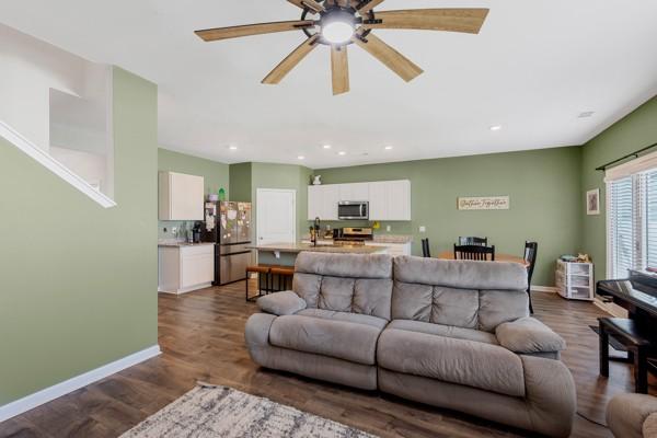 living area featuring dark wood finished floors, baseboards, a ceiling fan, and recessed lighting