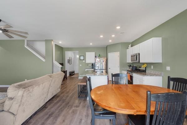 dining area featuring baseboards, recessed lighting, wood finished floors, stairway, and ceiling fan