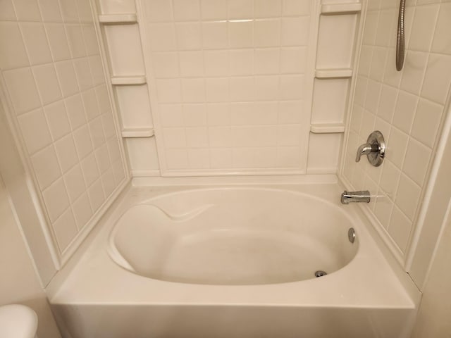 bathroom with toilet and bathing tub / shower combination