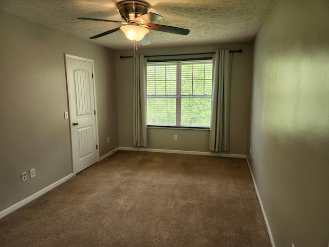 carpeted spare room featuring baseboards, ceiling fan, and a textured ceiling