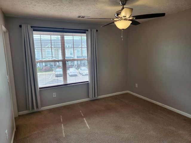 spare room with a wealth of natural light, carpet, ceiling fan, and visible vents