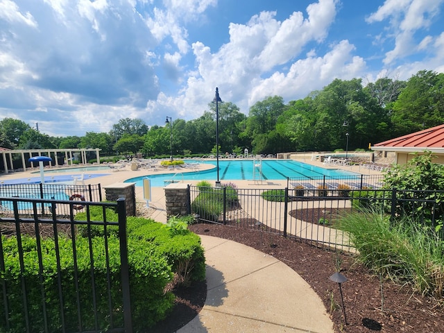 community pool with a patio and fence