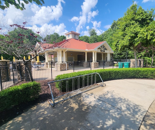 view of front of home featuring stucco siding, a patio area, fence, and metal roof