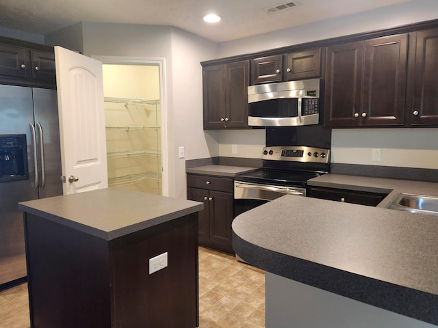 kitchen featuring recessed lighting, a center island, visible vents, dark brown cabinetry, and appliances with stainless steel finishes