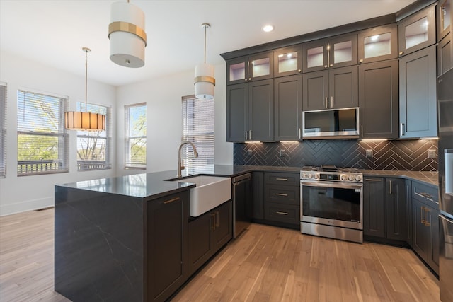 416 Mercomatic Dr, Nashville, TN 37209 - kitchen featuring dark countertops, light wood-type flooring, appliances with stainless steel finishes, and a sink
