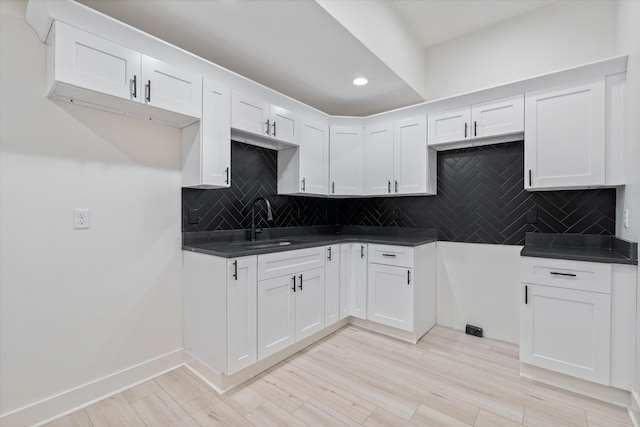 416 Mercomatic Dr, Nashville, TN 37209 - kitchen featuring light wood-style flooring, white cabinets, recessed lighting, dark countertops, and decorative backsplash