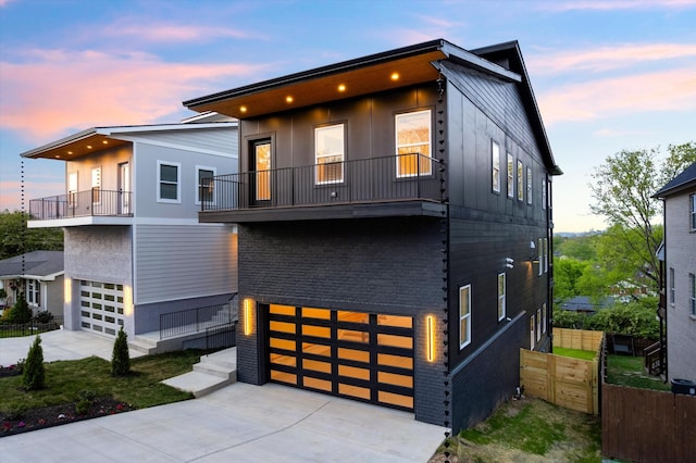 416 Mercomatic Dr, Nashville, TN 37209 - modern home featuring concrete driveway, an attached garage, brick siding, and a balcony