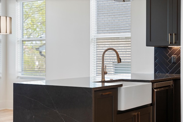 416 Mercomatic Dr, Nashville, TN 37209 - kitchen with backsplash, dark countertops, light wood-style floors, stainless steel dishwasher, and a sink