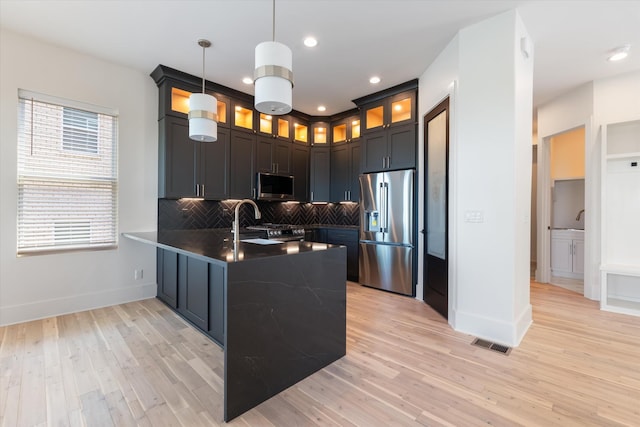 416 Mercomatic Dr, Nashville, TN 37209 - kitchen with baseboards, a peninsula, dark countertops, visible vents, and stainless steel appliances