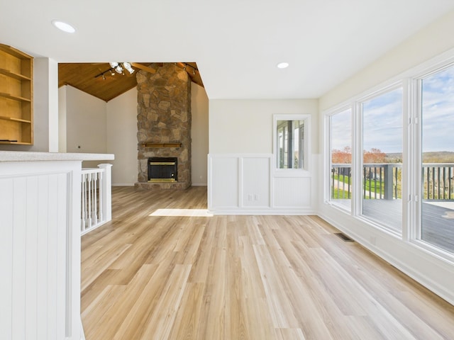 250 Sun Hill Cir, Cadiz, KY 42211 - unfurnished living room featuring a stone fireplace, vaulted ceiling, a ceiling fan, light wood-style floors, and visible vents