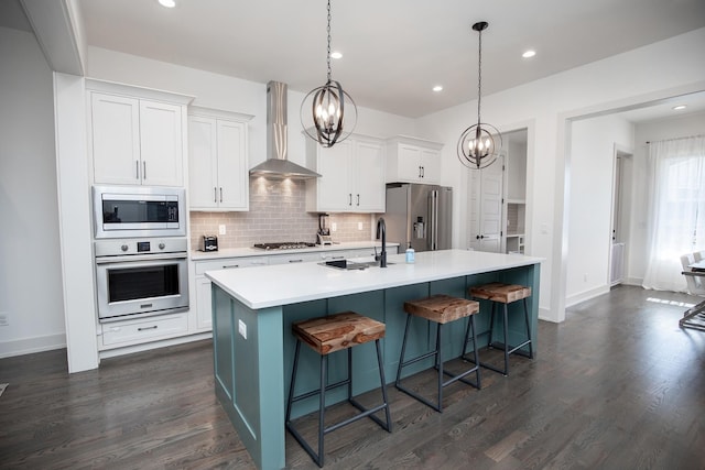 3509B Wrenwood Ave, Nashville, TN 37205 - kitchen featuring a notable chandelier, wall chimney range hood, an island with sink, decorative backsplash, and stainless steel appliances