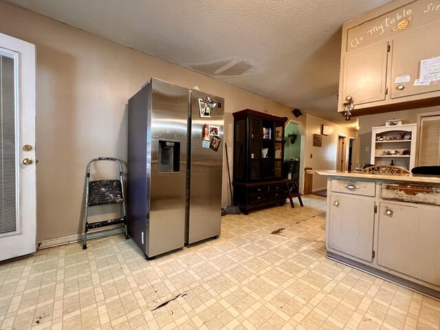 1112 Cumberland St, Decherd, TN 37324 - kitchen featuring baseboards, a textured ceiling, light countertops, and stainless steel fridge