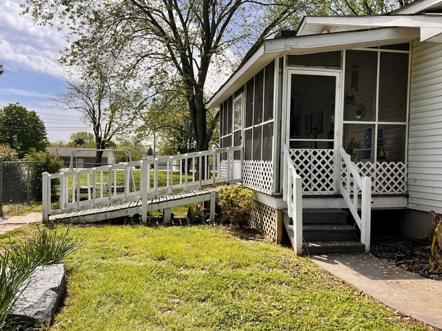 1112 Cumberland St, Decherd, TN 37324 - view of side of property featuring a deck, a sunroom, and a lawn