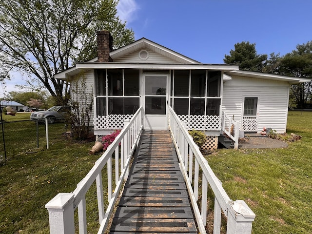 1112 Cumberland St, Decherd, TN 37324 - view of front facade featuring a sunroom, a chimney, and a front lawn