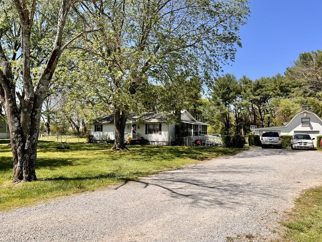 1112 Cumberland St, Decherd, TN 37324 - view of front of property featuring gravel driveway, fence, and a front yard